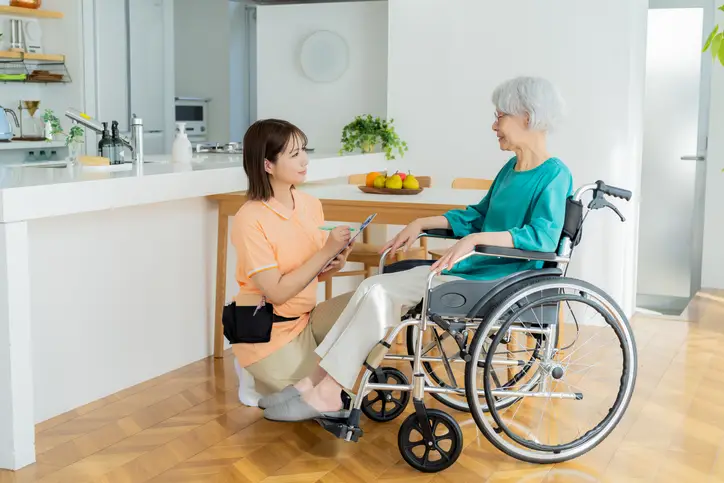 Aidant aidant soutenant une femme en fauteuil roulant